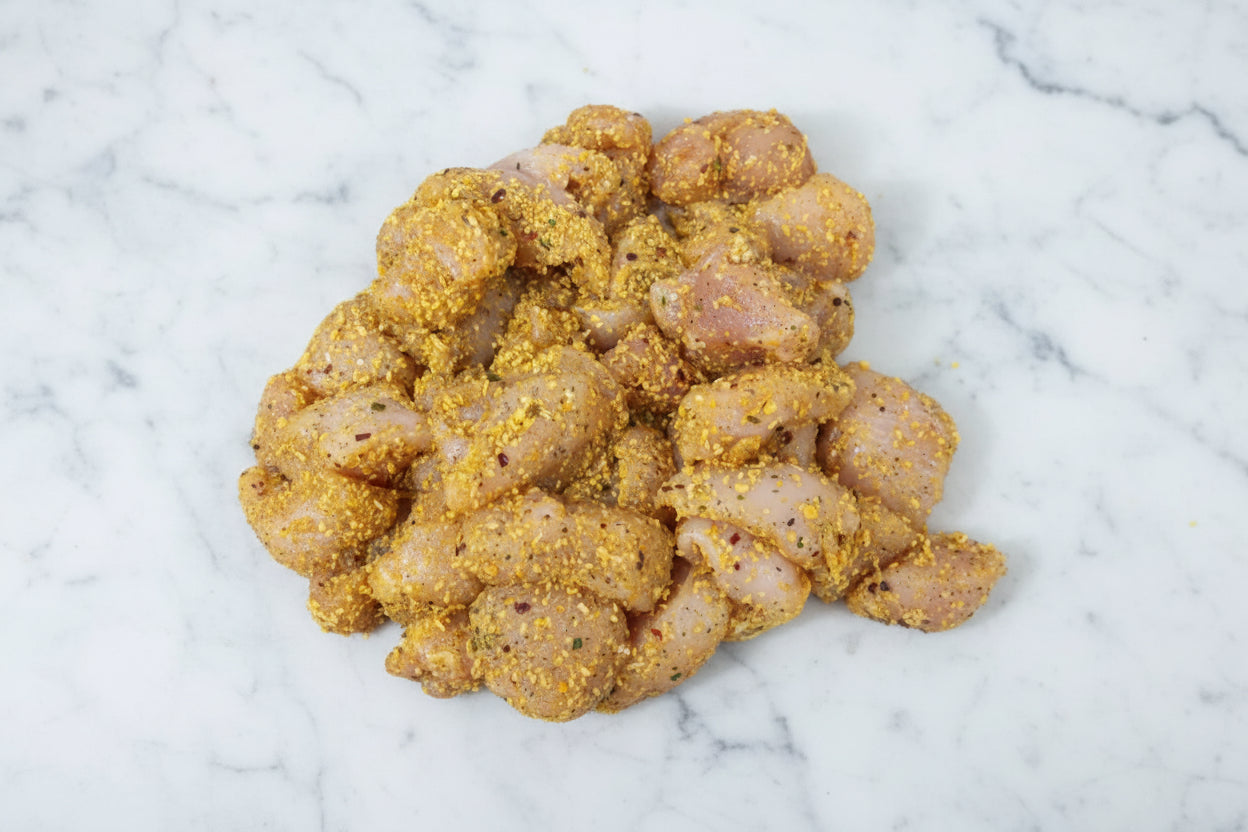 Marinated diced chicken fillets with visible seasoning.