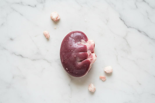 raw pigs kidney Place on a white marble background looking down on the product keeping a clean background to be suitable for a meat butchery